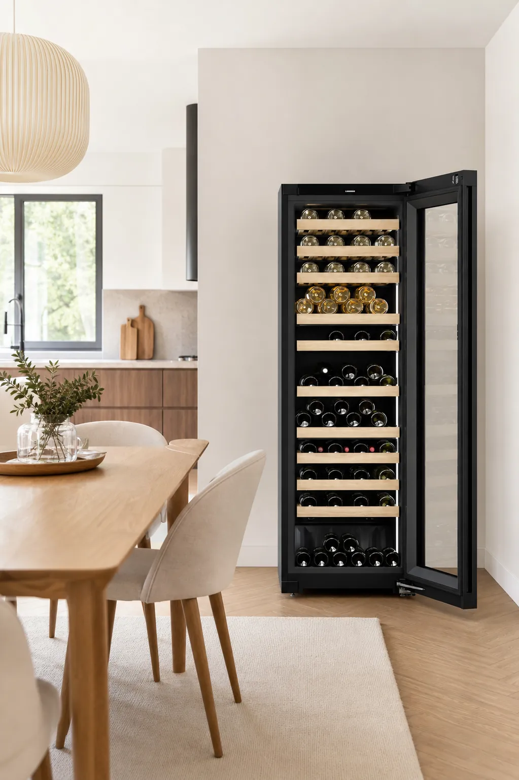 Czarna szafa na wino Liebherr w jasnym wnętrzu z otwartą kuchnią